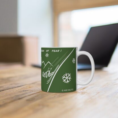 green ceramic skiers mug on a desk