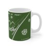 green ceramic mug with skiers and a cool quote