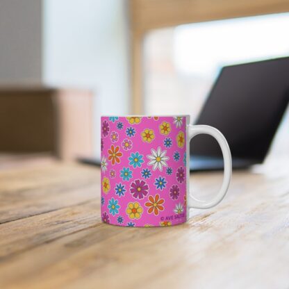 Campion a pink porcelain cup with floral print on desk.