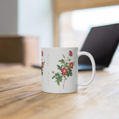 A stylish red Alpine Rose on a white porcelain cup that stands on a desk