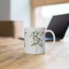 A pretty wild Burnet rose on a white porcelain cup that stands on a desk